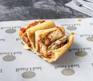 A sandwich cut in half sitting on top of a paper.