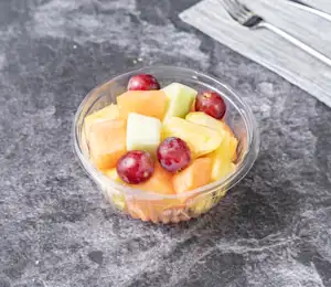 A bowl of fruit is sitting on the table.