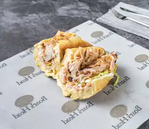 A sandwich cut in half on top of a paper.